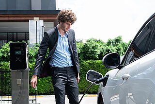 E-Mobilität Unternehmen. Mann lädt E-Auto an Wallbox