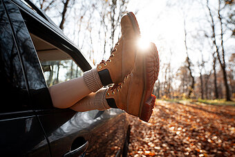 Mobilität und Tankstellen. Schuhe aus Autofenster